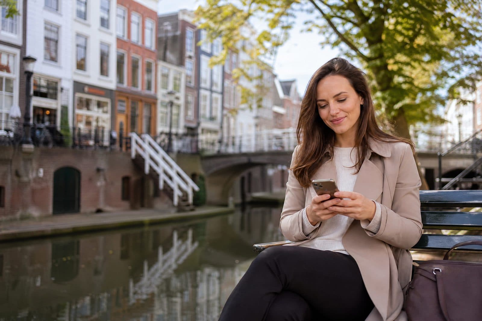 Vrolijke dame langs de gracht in Utrecht stelt een hulpvraag via haar mobiel